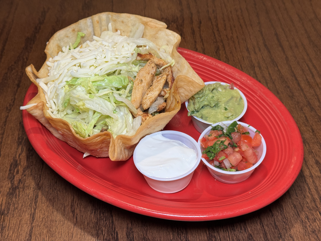 Chicken taco salad in crispy tortilla bowl