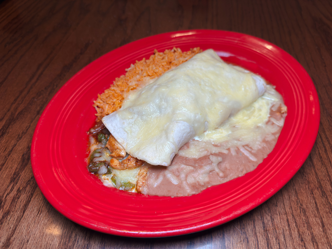Burrito smothered in cheese sauce with rice and beans